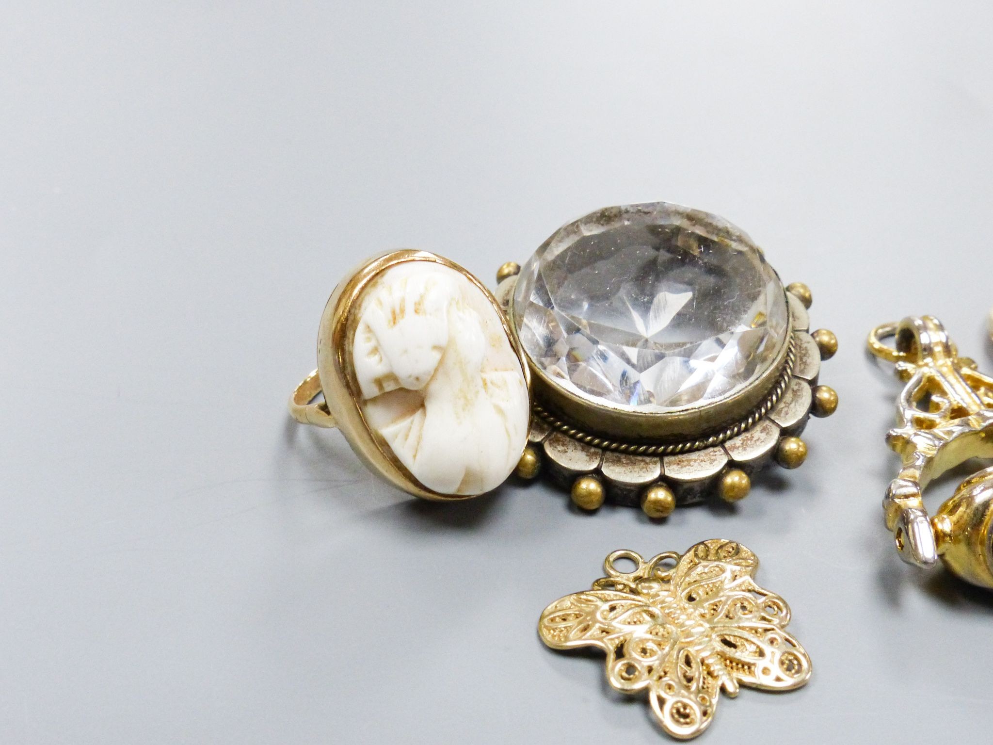 A 9ct gold cameo ring, a pair of similar earrings, yellow metal settings, a 9ct gold gem-set ring, a 'fob seal' pendant, a silver-gilt butterfly pendant and a clear paste-set pendant